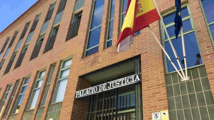Fachada del Palacio de Justicia con las banderas de España y la Unión Europea