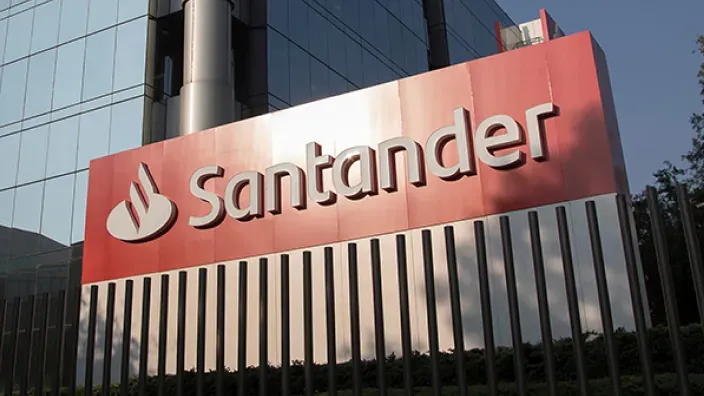 Fachada de un edificio corporativo del Banco Santander con su logotipo en grande.