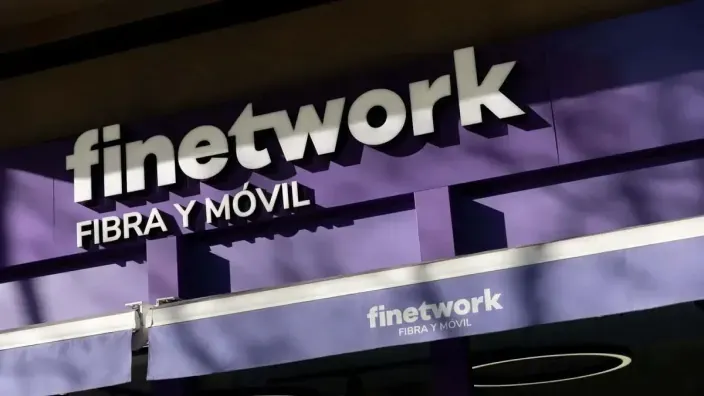 Primer plano del logo de Finetwork en la fachada de una de sus tiendas, que destaca sus servicios de fibra y móvil.