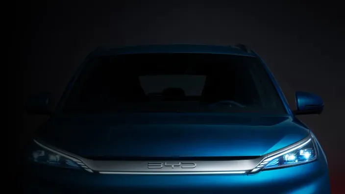 Vista frontal de un coche BYD azul con luces LED encendidas.