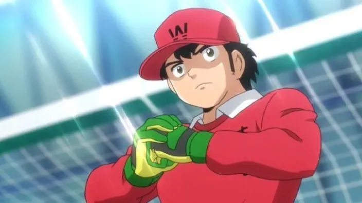 Genzo Wakabayashi con gorra roja y guantes verdes en una escena de Captain Tsubasa