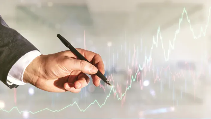 Mano señalando un gráfico bursátil en crecimiento que representa la evolución de los mercados financieros