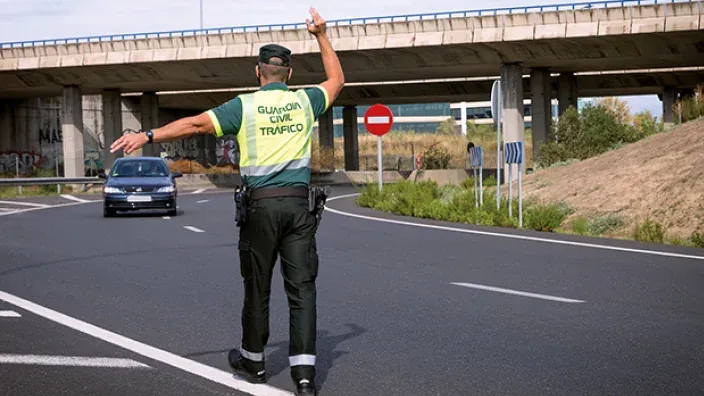 Un guardia civil de tráfico manda detenerse a un coche para realizarle un control.