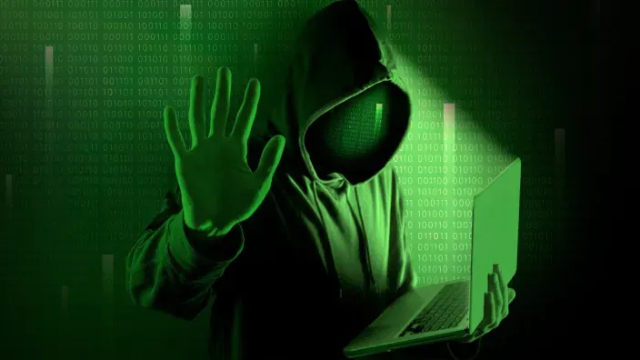 Persona con guantes sosteniendo un teléfono móvil con el logotipo de WhatsApp en la pantalla, representando una posible estafa digital.