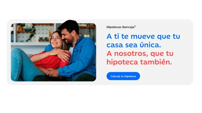 Pareja sonriente abrazada en el sofá sobre un anuncio de hipotecas de Ibercaja.