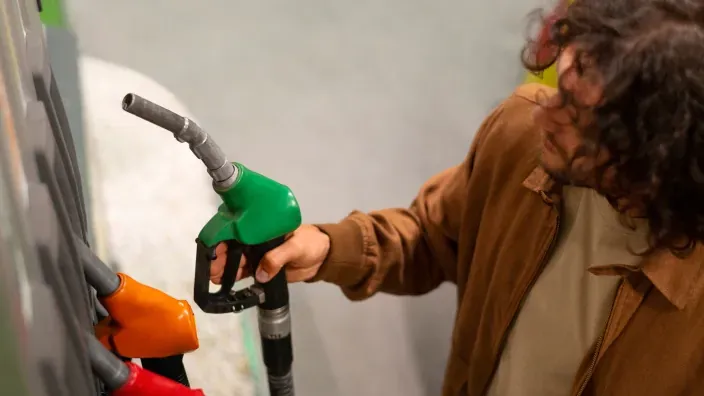 Hombre repostando combustible en una gasolinera