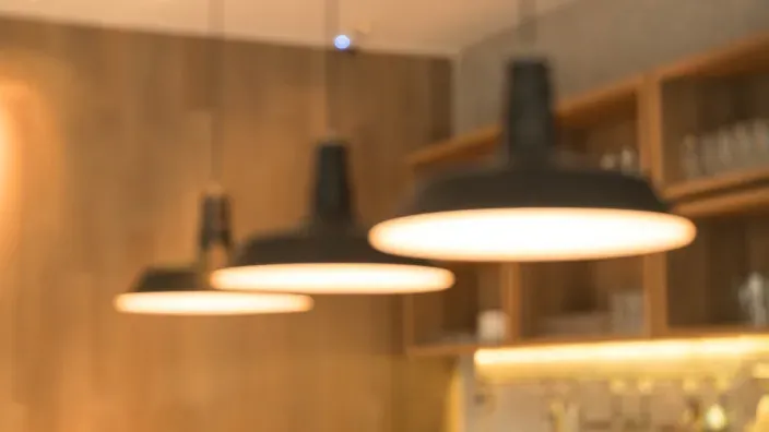 Lámparas de techo encendidas en el interior de una vivienda que reflejan el consumo de electricidad en el hogar