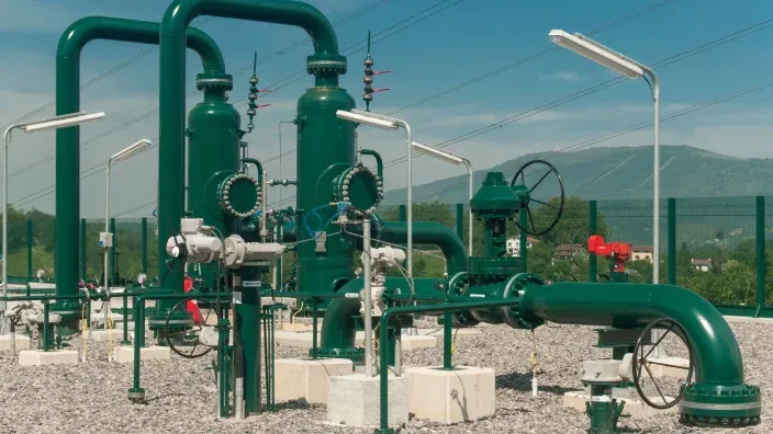 Infraestructura de gas natural con tuberías y válvulas en una planta industrial gestionada por Enagás.