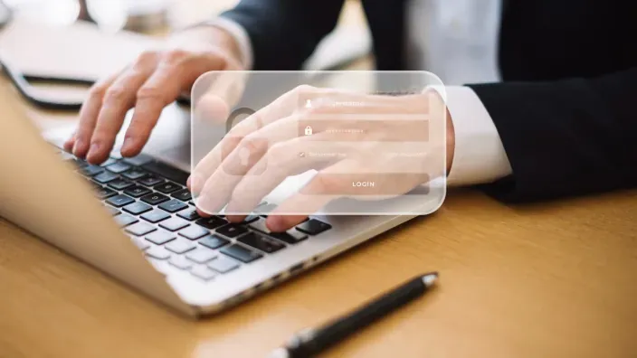 Persona introduciendo su contraseña en un portátil con interfaz de login digital para ciberseguridad.
