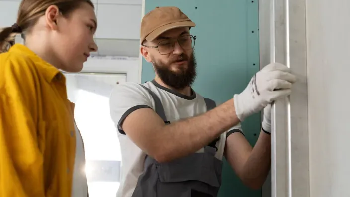 Técnico explicando a propietaria la instalación de aislamiento en hogar.