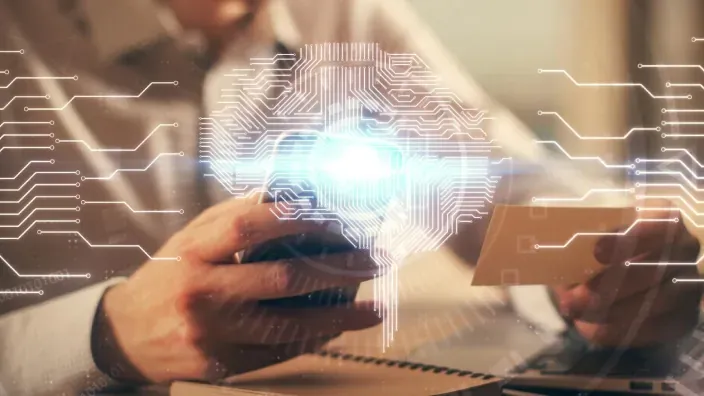 Representación de inteligencia artificial con un cerebro digital superpuesto mientras una persona utiliza un smartphone y una tarjeta bancaria.