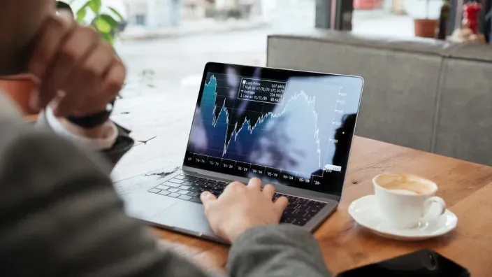 PErsona haciendo inversión a través de su ordenador portátil.