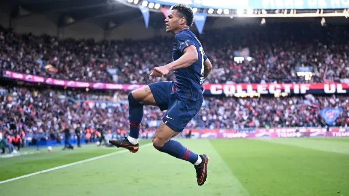 Jugador del PSG celebrando un gol durante un partido con la grada llena al fondo