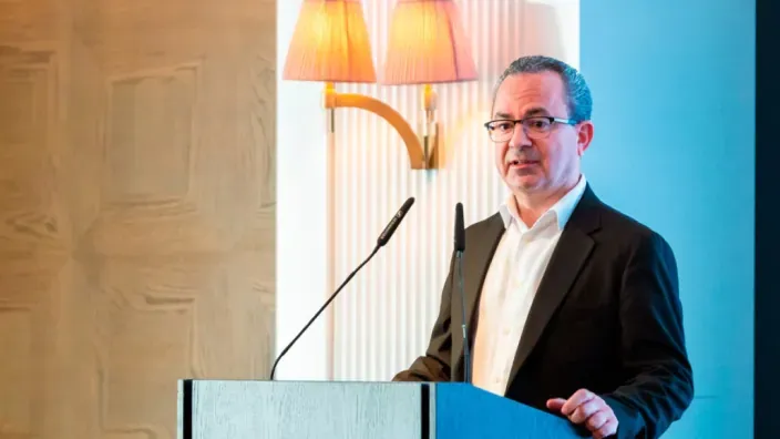 Julio César Nieto, presidente de ACIE, durante una conferencia con micrófono y fondo institucional