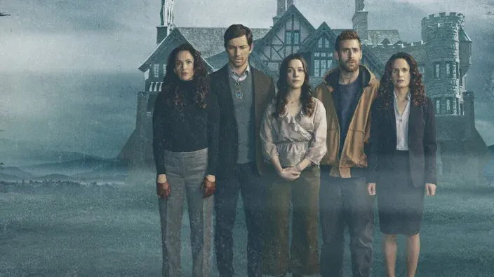 Imagen promocional de La Maldición de Hill House con una familia delante de una mansión terrorífica.