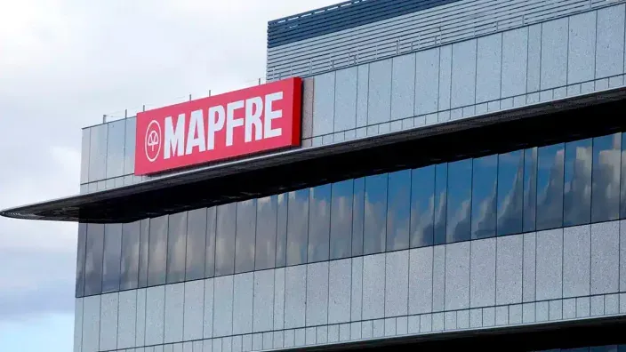 Fachada de un edificio moderno con el logotipo de Mapfre en un cartel rojo.