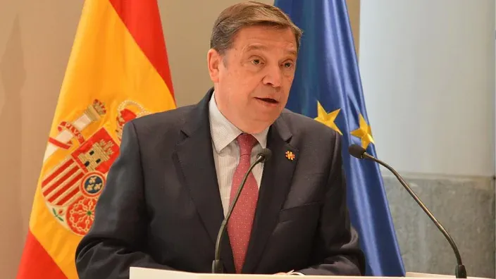 Luis Planas, ministro de Agrocultura, habla en un atril en un acto institucional.