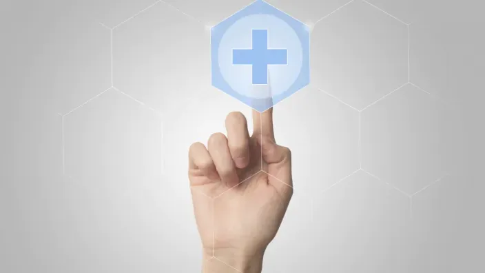 Mano pulsando un icono de salud digital con una cruz sobre fondo gris