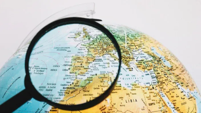 Lupa ampliando el mapa de España y el Mediterráneo en un globo terráqueo físico.