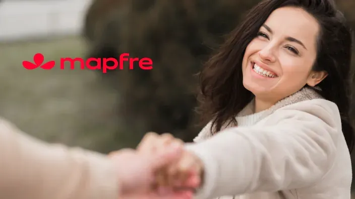 Una mujer sonriendo y agarrando la mano de otra persona.