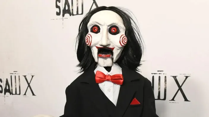 La marioneta de Saw en una imagen promocional con fondo blanco.