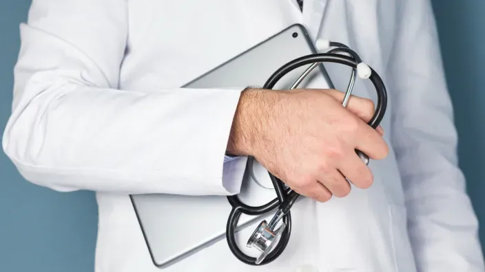 Médico con una tablet y un fonendoscopio en la mano
