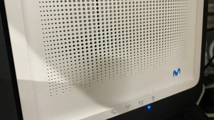 Primer plano de un módem blanco de Movistar con luces indicadoras encendidas.
