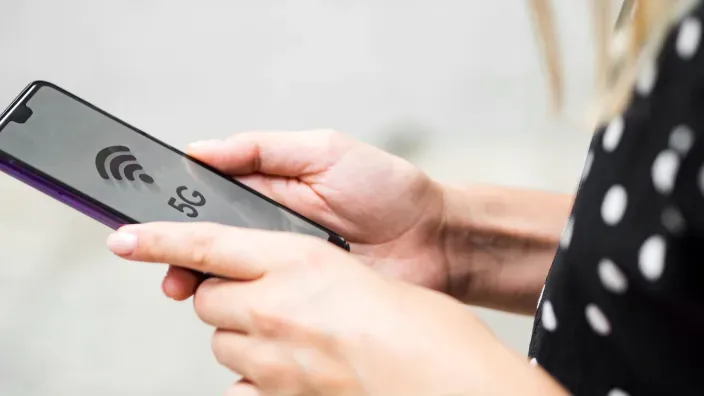 Mujer conectada a la red 5G en su smartphone. Concepto de la nueva generación de internet móvil y la tecnología de alta velocidad.