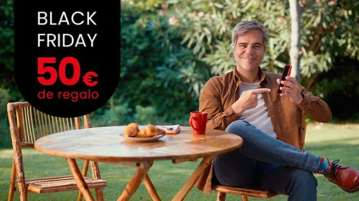 Oferta de Black Friday. Ernesto Sevilla en un jardín señala su móvil. Consigue 50€ de regalo al contratar tu tarifa.