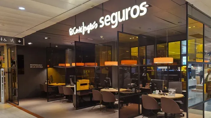 Oficina de seguros de El Corte Inglés con puestos de atención al cliente y diseño moderno en un centro comercial.