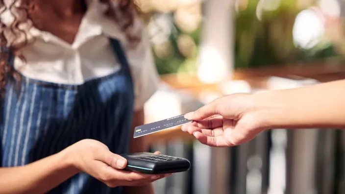Cliente realizando un pago con tarjeta en un comercio físico mediante datáfono