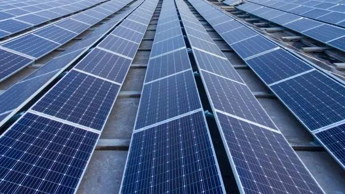 Filas de paneles solares fotovoltaicos captando energía del sol en una instalación industrial.