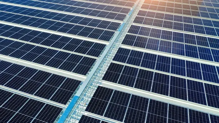 Instalación de paneles solares fotovoltaicos en el tejado de un edificio para el autoconsumo de energía renovable.