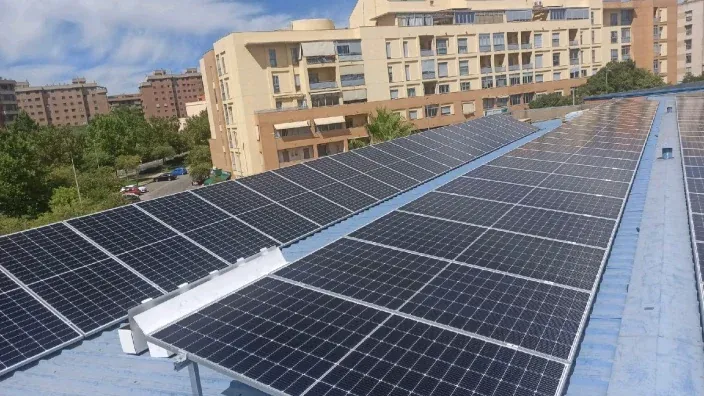 Un edificio con el tejado cubierto por paneels solares fotovoltaicos.