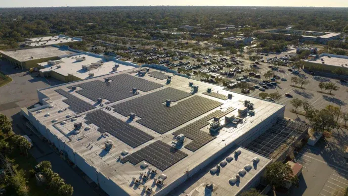 Vista aérea de un edificio comercial con paneles solares instalados en la cubierta.