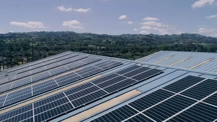 Instalación de paneles solares fotovoltaicos en el tejado de una nave industrial construida por TotalEnergies en colaboración con GAM