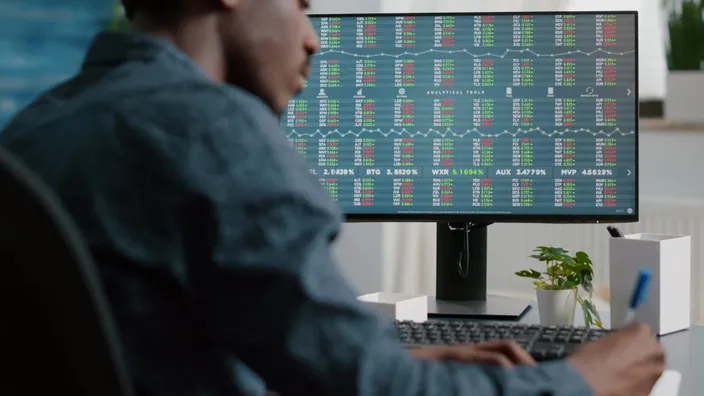 Inversor o trader analizando gráficos y datos del mercado de valores en tiempo real. Estrategia de inversión y finanzas.