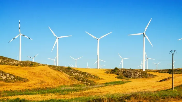 Aerogeneradores en funcionamiento en un parque eólico sobre colinas rurales