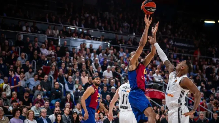 Partido de baloncesto entre Real Madrid y FC Barcelona en la Euroliga con jugadores en acción bajo el aro.
