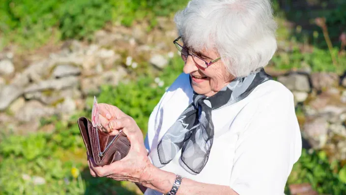 Mujer jubilada sonriente gestionando su pensión.