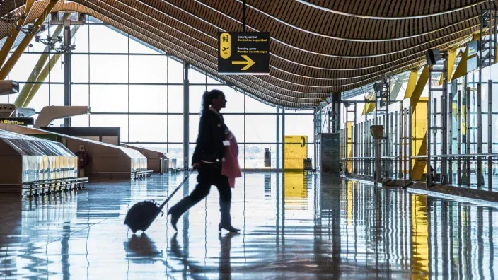 Persona caminando con una maleta por el interior de un aeropuerto