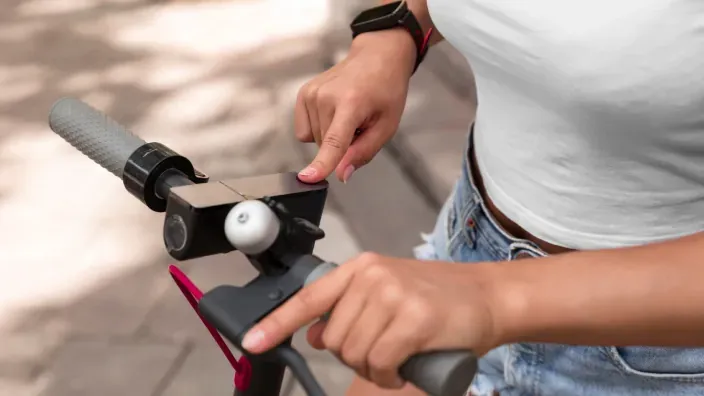 Usuario activando un patinete electrico antes de iniciar un desplazamiento urbano.