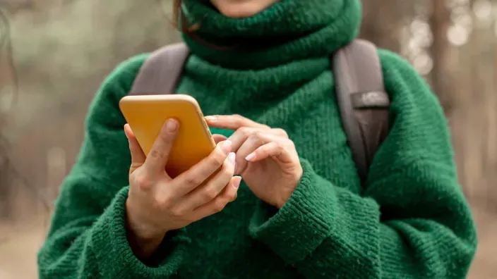 Mujer usando en su smarphone la app de mensajería WhatsApp.