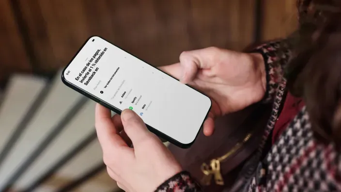 Persona sosteniendo un móvil con la aplicación de Trade Republic en la pantalla