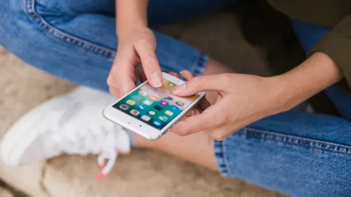 Primer plano de una persona usando su smartphone para navegar entre las apps.