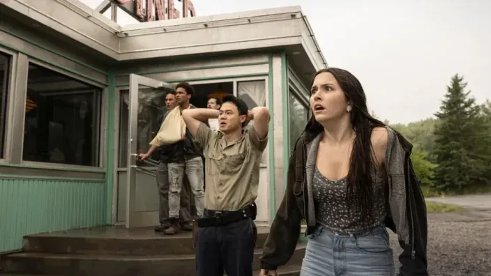 Varios personajes de From saliendo de un edificio del pueblo.