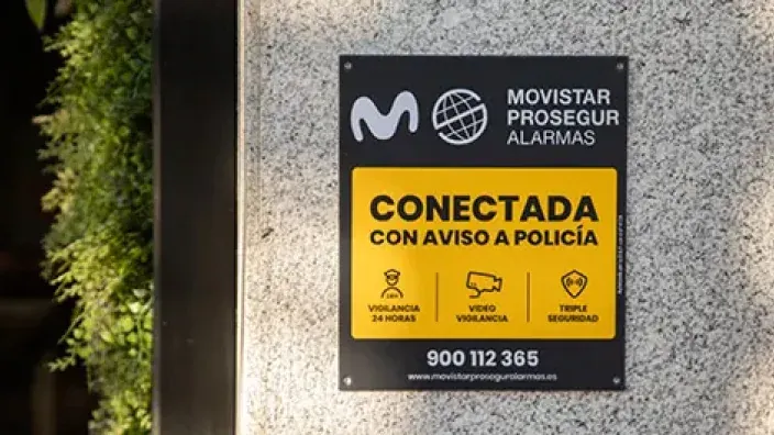 Placa disuasoria de la alarma de Movistar Prosegur, conectada con la policía y con vigilancia 24 horas, en la fachada de una vivienda.