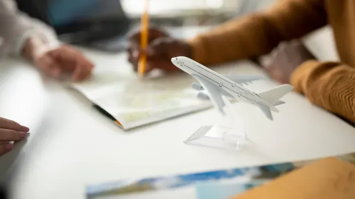 Planificación de viaje con maqueta de avión sobre la mesa