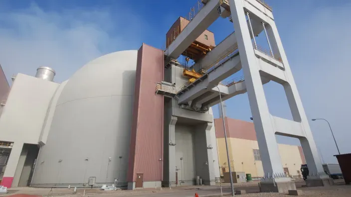 Instalaciones exteriores de una planta nuclear con estructuras industriales y domo del reactor.