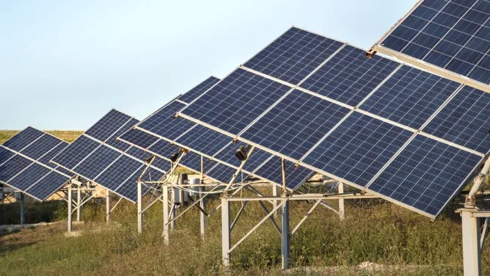 Planta solar fotovoltaica con paneles solares inclinados en campo abierto, utilizada para la producción de energía limpia y sostenible.